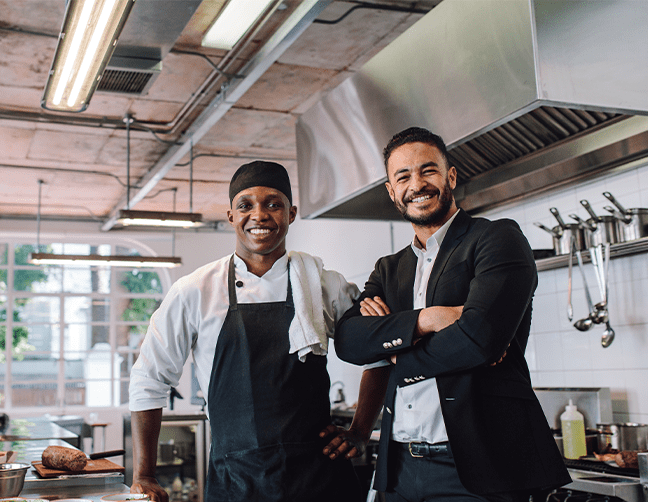 restaurant owner and chef smiling in kitchen