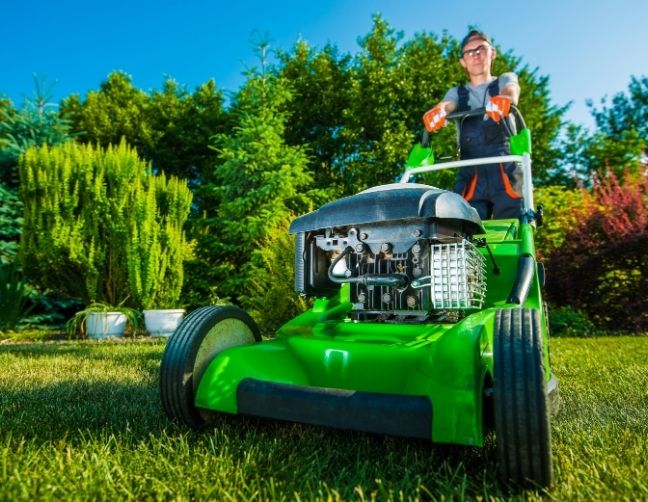 lawn care business owner mowing a customer's yard