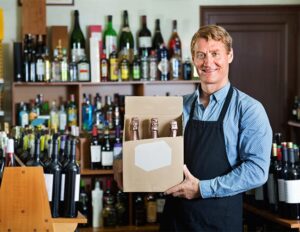 liquor store owner holding box of inventory